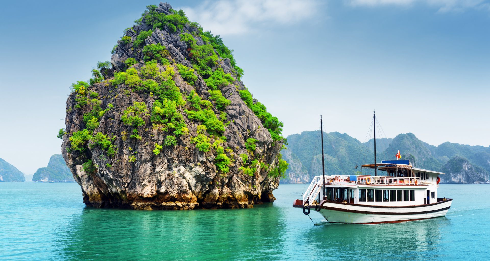 Beautiful view of karst isle and tourist boat in the Ha Long Bay